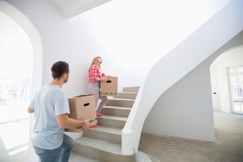 Removal team handling boxes and furniture in a West London flat