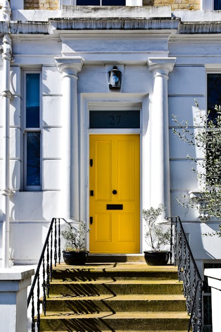 The image shows a two-storey green building with a sign reading 'Notting Hill Garage' and details about vehicle sales and repairs, situated on a street in Notting Hill. A dark blue vintage station wag